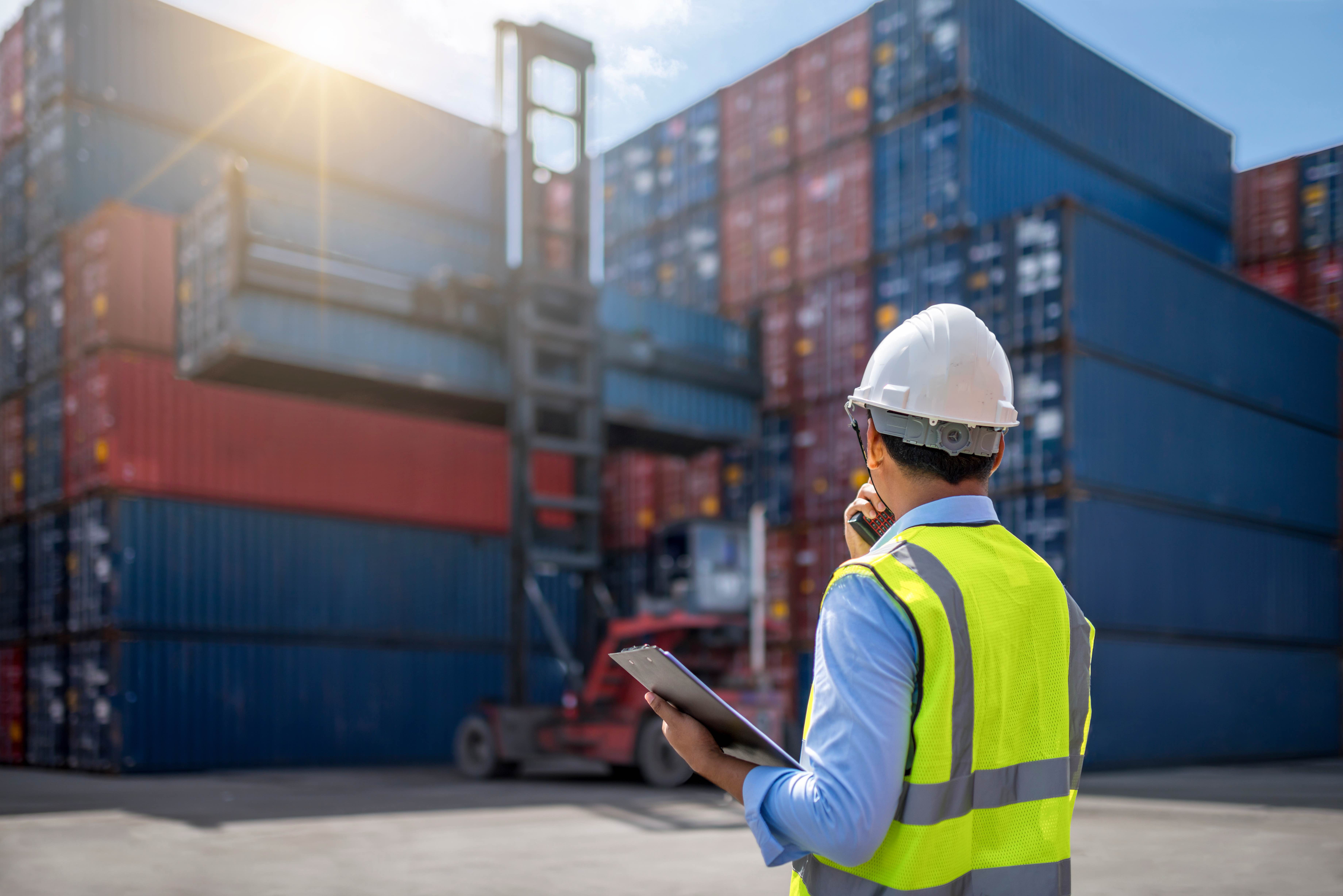 Picture of a man in a hardhat looking at some containers