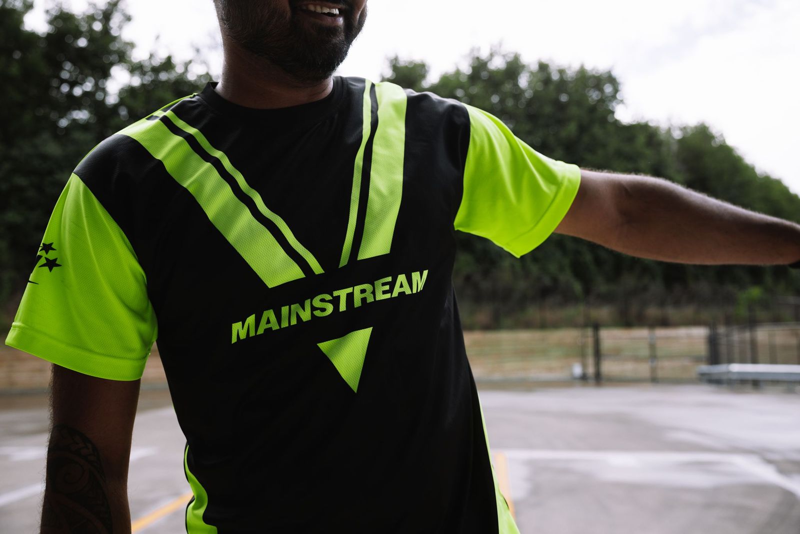 Image of a set of three Mainstream posters with a man walking in-front of them