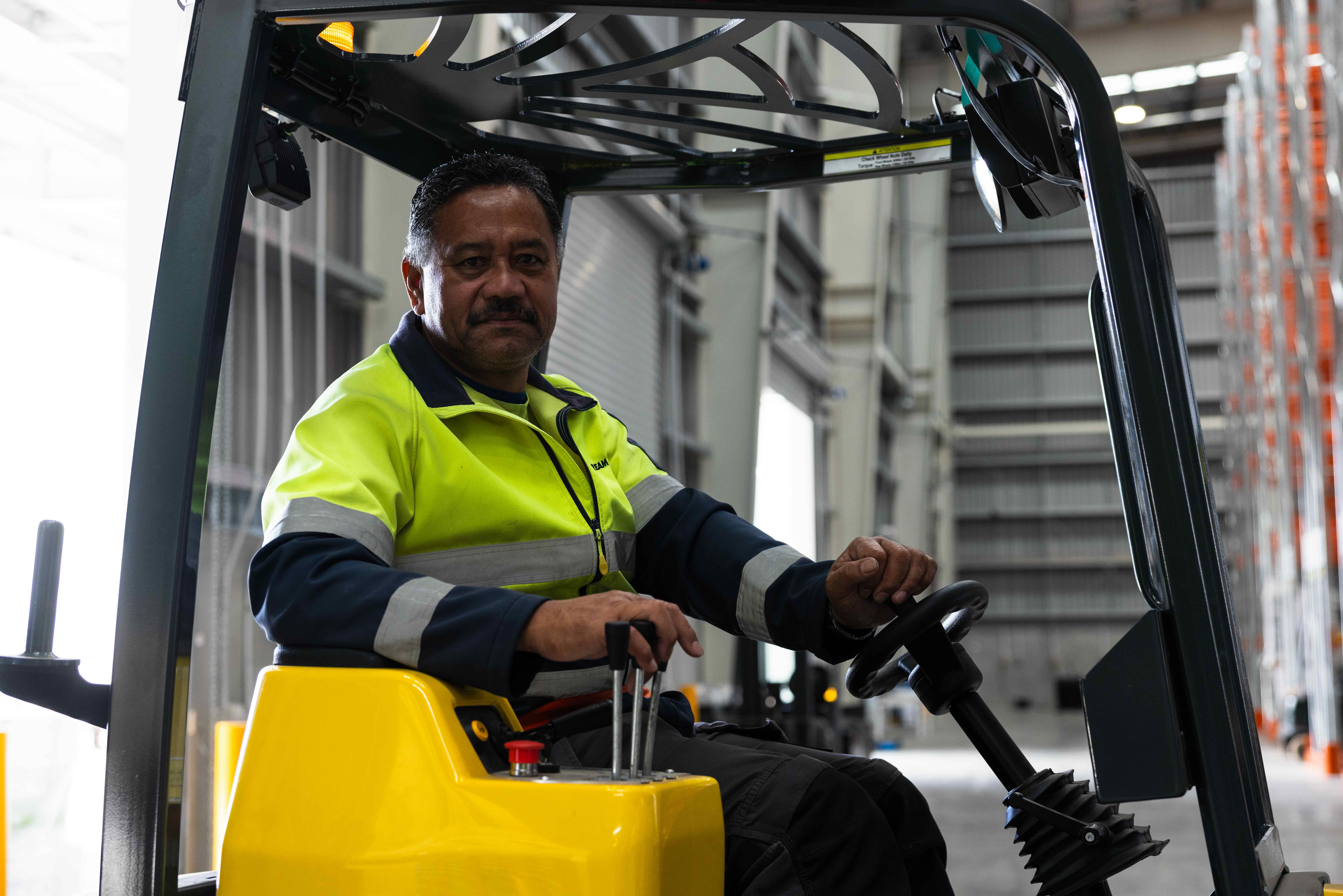 Image of a Mainstream staff member looking at camera while on a forklift